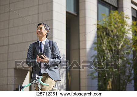 Middle Aged Japanese Businessman Riding A Bicycle View Large Photo Image Stock Image - Middle Aged Japanese Businessman Riding A Bicycle. Fotosearch