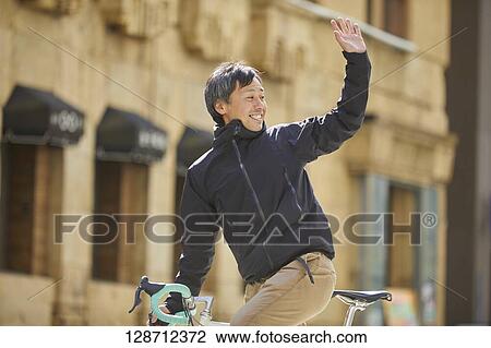 Stock Image - Middle Aged Japanese Businessman Riding A Bicycle. Fotosearch