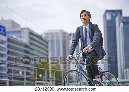 Middle Aged Japanese Businessman Riding A Bicycle View Large Photo Image Stock Image - Middle Aged Japanese Businessman Riding A Bicycle. Fotosearch