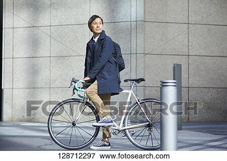 Middle Aged Japanese Businessman Riding A Bicycle View Large Photo Image Stock Photo - Middle Aged Japanese Businessman Riding A Bicycle. Fotosearch