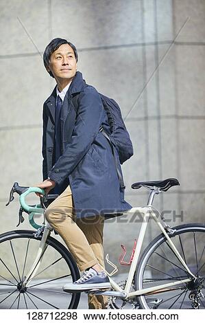 Middle Aged Japanese Businessman Riding A Bicycle View Large Photo Image Stock Photo - Middle Aged Japanese Businessman Riding A Bicycle. Fotosearch