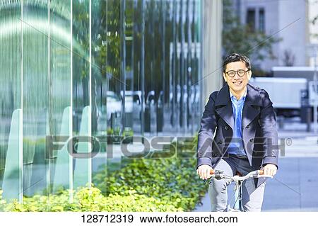Middle Aged Japanese Businessman Riding A Bicycle View Large Photo Image Stock Photo - Middle Aged Japanese Businessman Riding A Bicycle. Fotosearch