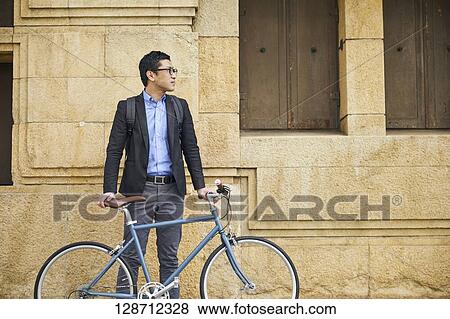 Middle Aged Japanese Businessman Riding A Bicycle View Large Photo Image Stock Photo - Middle Aged Japanese Businessman Riding A Bicycle. Fotosearch