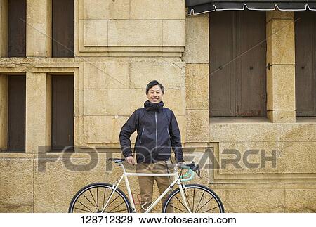 Middle Aged Japanese Businessman Riding A Bicycle View Large Photo Image Stock Photo - Middle Aged Japanese Businessman Riding A Bicycle. Fotosearch