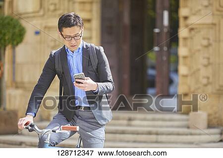Middle Aged Japanese Businessman Riding A Bicycle View Large Photo Image Stock Photo - Middle Aged Japanese Businessman Riding A Bicycle. Fotosearch