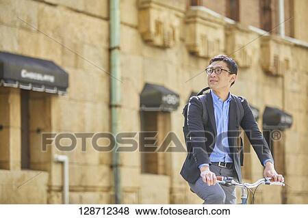 Middle Aged Japanese Businessman Riding A Bicycle View Large Photo Image Stock Photo - Middle Aged Japanese Businessman Riding A Bicycle. Fotosearch