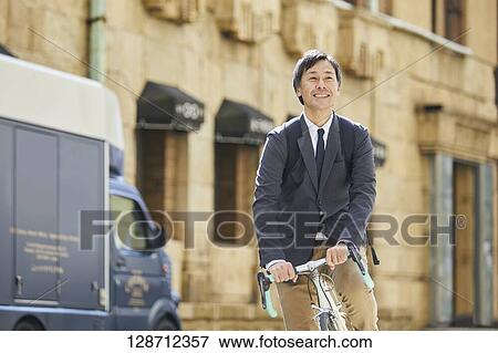 Middle Aged Japanese Businessman Riding A Bicycle View Large Photo Image Stock Photo - Middle Aged Japanese Businessman Riding A Bicycle. Fotosearch