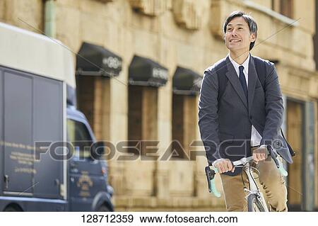 Middle Aged Japanese Businessman Riding A Bicycle View Large Photo Image Stock Photo - Middle Aged Japanese Businessman Riding A Bicycle. Fotosearch