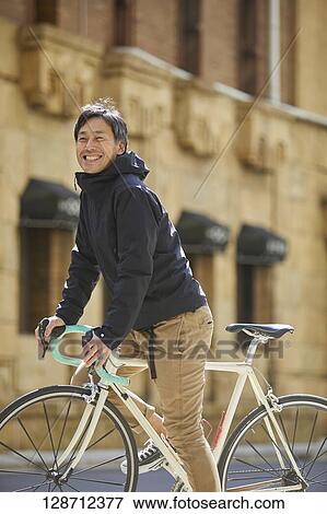 Middle Aged Japanese Businessman Riding A Bicycle View Large Photo Image Stock Photo - Middle Aged Japanese Businessman Riding A Bicycle. Fotosearch