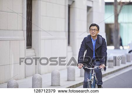 Middle Aged Japanese Businessman Riding A Bicycle View Large Photo Image Stock Photo - Middle Aged Japanese Businessman Riding A Bicycle. Fotosearch