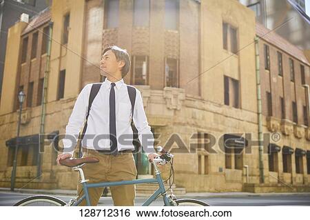 Stock Photograph - Middle Aged Japanese Businessman Riding A Bicycle. Fotosearch