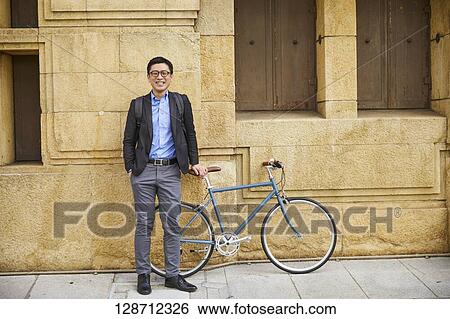 Stock Photograph - Middle Aged Japanese Businessman Riding A Bicycle. Fotosearch