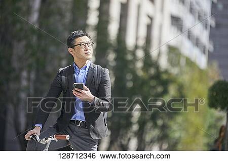 Middle Aged Japanese Businessman Riding A Bicycle View Large Photo Image Stock Photograph - Middle Aged Japanese Businessman Riding A Bicycle. Fotosearch