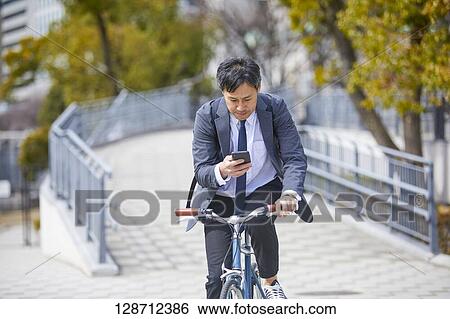 Stock Photograph - Middle Aged Japanese Businessman Riding A Bicycle. Fotosearch