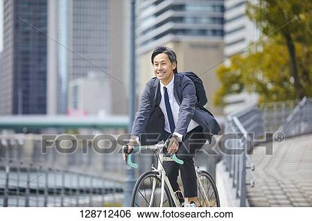 Middle Aged Japanese Businessman Riding A Bicycle View Large Photo Image Stock Photograph - Middle Aged Japanese Businessman Riding A Bicycle. Fotosearch
