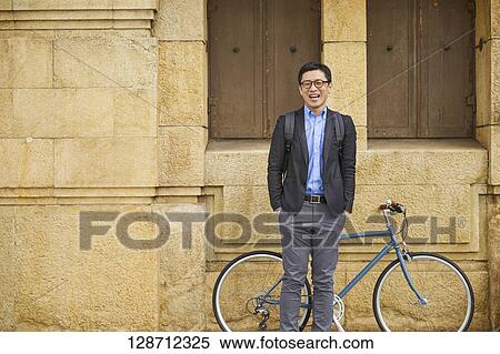 Stock Photography - Middle Aged Japanese Businessman Riding A Bicycle. Fotosearch