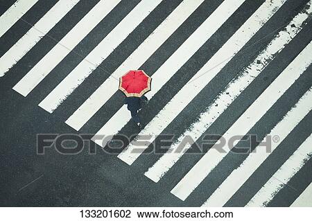 Stock Image - People Crossing A Crossroad On A Rainy Day In Tokyo, Japan. Fotosearch