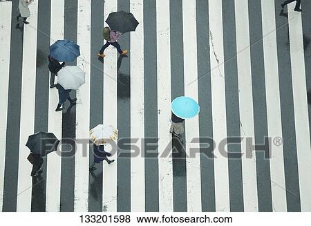 Stock Photo - People Crossing A Crossroad On A Rainy Day In Tokyo, Japan. Fotosearch