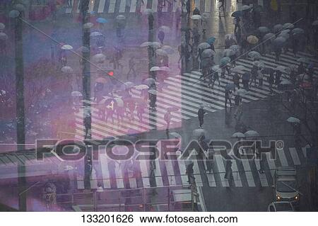 Stock Photograph - People Crossing A Crossroad On A Rainy Day In Tokyo, Japan. Fotosearch