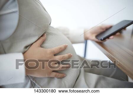Pregnant Japanese woman with smartphone View Large Photo Image Stock Image - Pregnant Japanese woman with smartphone. Fotosearch