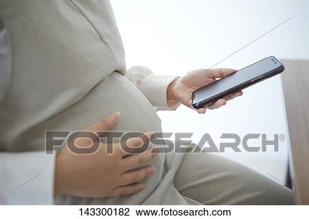 Pregnant Japanese woman with smartphone View Large Photo Image Stock Image - Pregnant Japanese woman with smartphone. Fotosearch