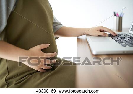 Pregnant Japanese woman working with laptop View Large Photo Image Stock Photo - Pregnant Japanese woman working with laptop. Fotosearch