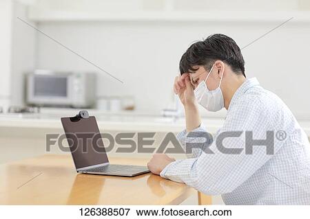 Sick Japanese man working from home View Large Photo Image Stock Photo - Sick Japanese man working from home. Fotosearch