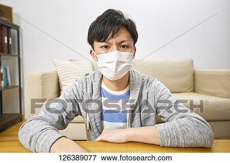 Sick Japanese man working from home View Large Photo Image Stock Photo - Sick Japanese man working from home. Fotosearch