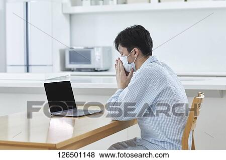 Sick Japanese man working from home View Large Photo Image Stock Photo - Sick Japanese man working from home. Fotosearch