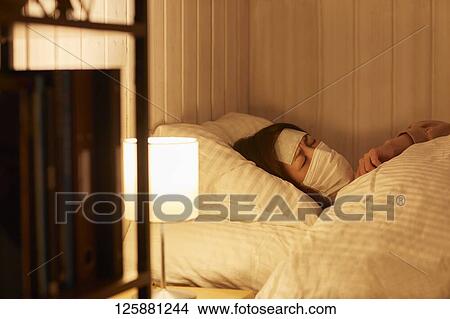 Picture - Sick Japanese woman at home. Fotosearch
