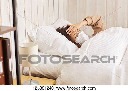 Stock Image - Sick Japanese woman at home. Fotosearch