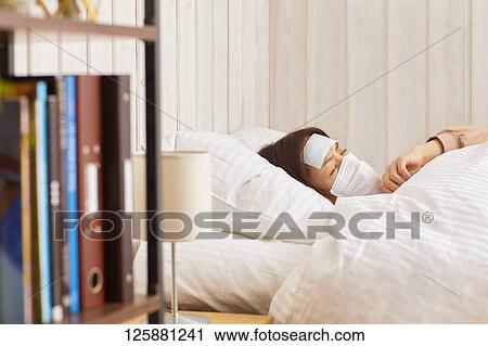 Stock Image - Sick Japanese woman at home. Fotosearch