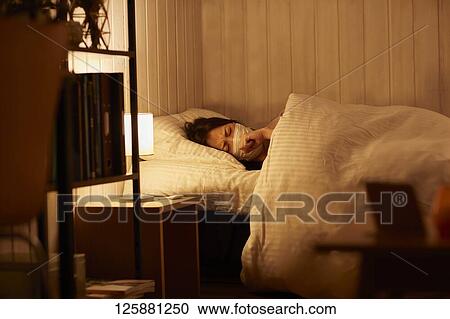 Stock Image - Sick Japanese woman at home. Fotosearch