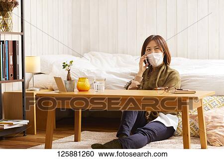 Stock Image - Sick Japanese woman at home. Fotosearch