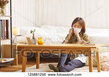 Stock Photograph - Sick Japanese woman at home. Fotosearch