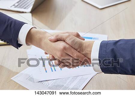 Top-down view of business people shaking hands in the office View Large Photo Image Stock Image - Top-down view of business people shaking hands in the office. Fotosearch