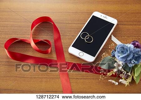 Picture - Wedding Rings On The Smartphone. Fotosearch