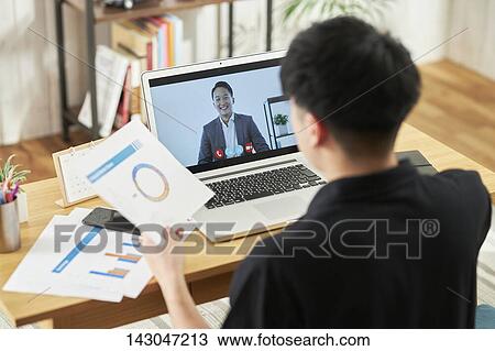 Stock Image - Young Japanese businessman working with laptop. Fotosearch