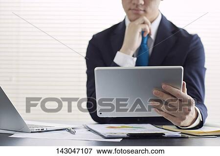 Young Japanese businessman working with tablet View Large Photo Image Stock Photo - Young Japanese businessman working with tablet. Fotosearch