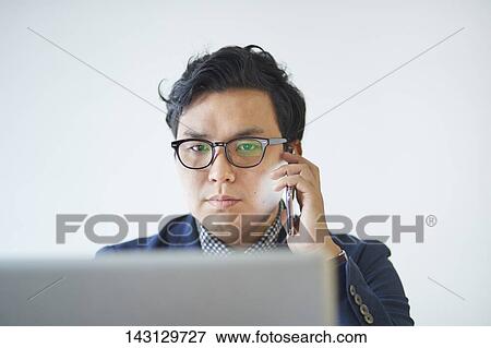 Young Japanese businessman working with laptop View Large Photo Image Stock Photo - Young Japanese businessman working with laptop. Fotosearch