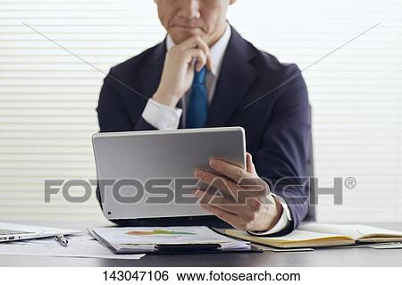 Young Japanese businessman working with tablet View Large Photo Image Stock Photograph - Young Japanese businessman working with tablet. Fotosearch