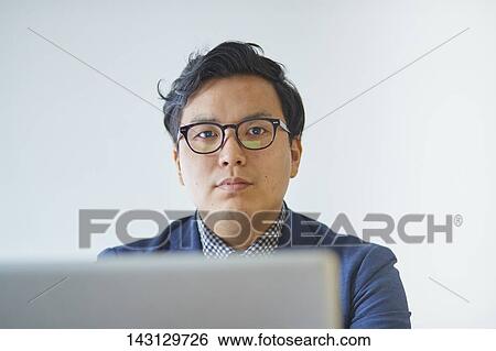 Young Japanese businessman working with laptop View Large Photo Image Stock Photograph - Young Japanese businessman working with laptop. Fotosearch