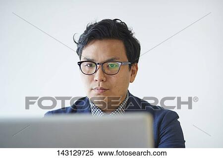 Young Japanese businessman working with laptop View Large Photo Image Stock Photography - Young Japanese businessman working with laptop. Fotosearch