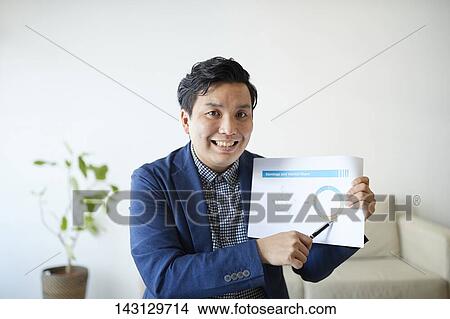 Picture - Young Japanese man having a remote video call. Fotosearch