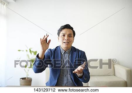 Young Japanese man having a remote video call View Large Photo Image Stock Image - Young Japanese man having a remote video call. Fotosearch