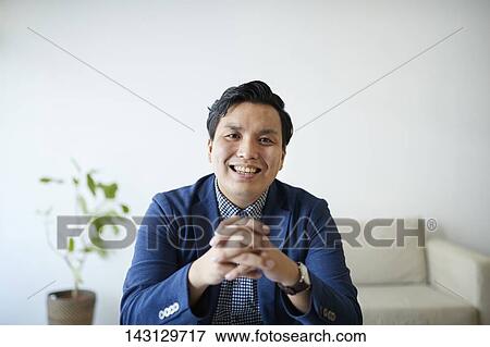 Stock Photo - Young Japanese man having a remote video call. Fotosearch
