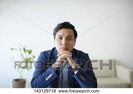 Young Japanese man having a remote video call View Large Photo Image Stock Photo - Young Japanese man having a remote video call. Fotosearch