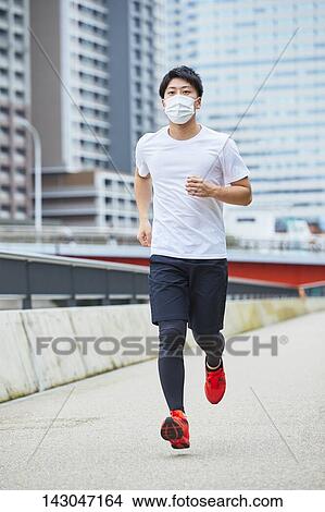 Picture - Young Japanese man training downtown Tokyo. Fotosearch