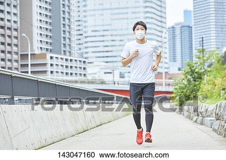 Stock Image - Young Japanese man training downtown Tokyo. Fotosearch