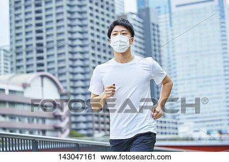 Stock Image - Young Japanese man training downtown Tokyo. Fotosearch
